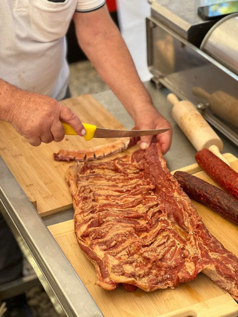 nea-ticu-carnati-de-plescoi-bacania-lu-nea-ticu-traditii-culinare-produse-traditionale-gastronomie-romaneasca-buzau-producatori-locali-carne-artizanala-carnatar-retete-de-familie-afaceri-de-familie-comunitati-rurale-mestesuguri-traditionale-patrimoniu-gastronomic-satul-romanesc-pastrama-de-oaie-productie-artizanala